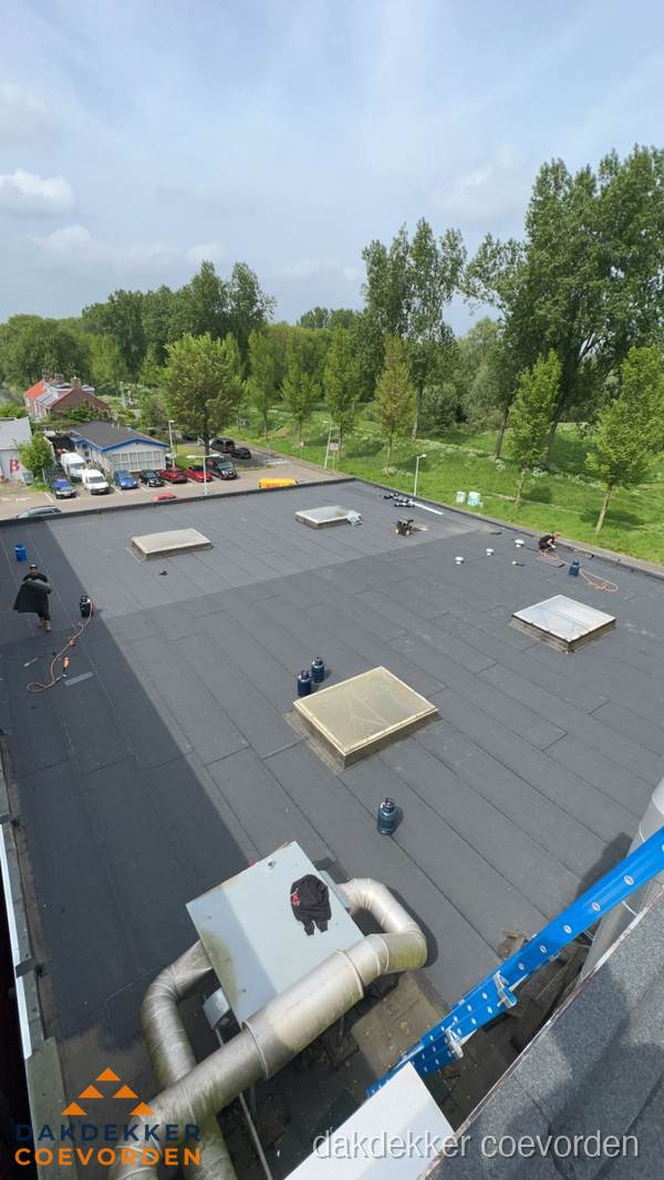 Dakdekker aan het werk op groot plat dak met bitumen in Coevorden Dakdekker aan het werk op groot plat dak met bitumen in Coevorden